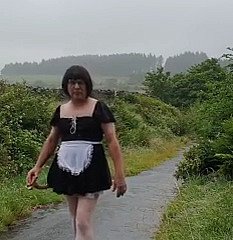 Transvestitenmädchen nigh einer öffentlichen Gasse im Regen